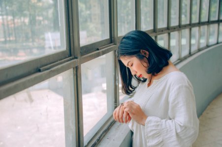 Woman In White Sweater In Front Of Window photo