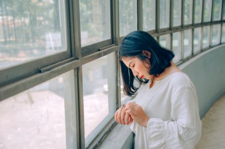 Woman In White Sweater In Front Of Window