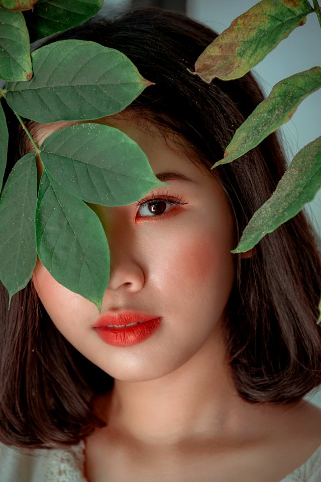 Close-Up Photography Of A Woman Near Leaves