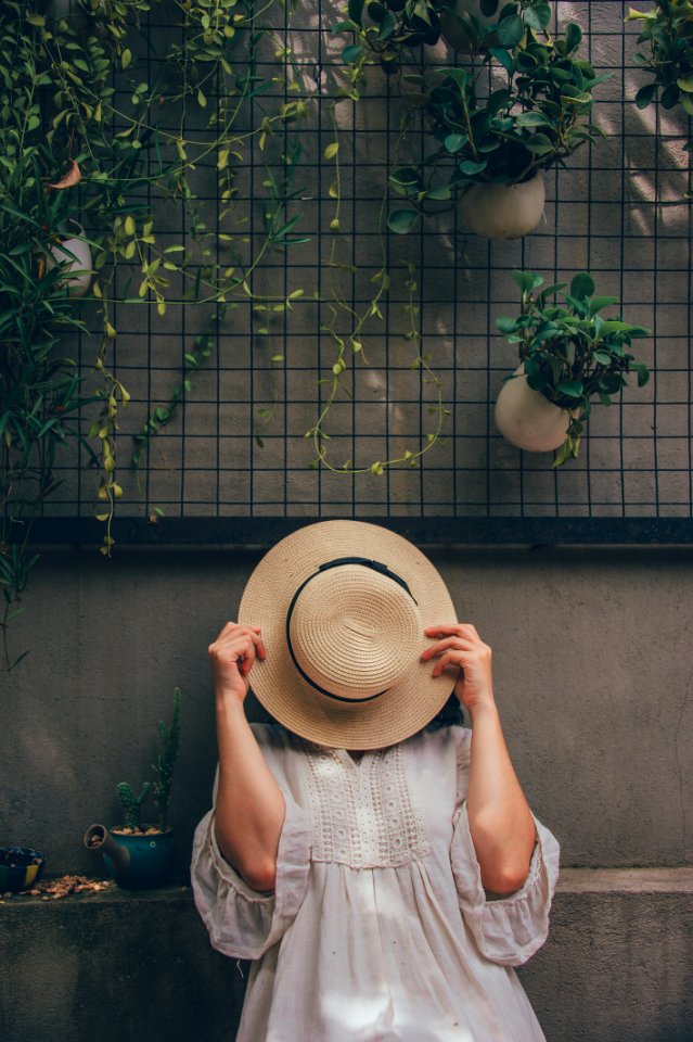 Woman Holding A Brown Hat