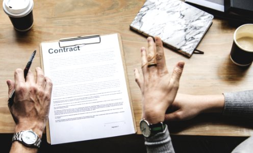 Person Holding Pen In Front Of Contract photo