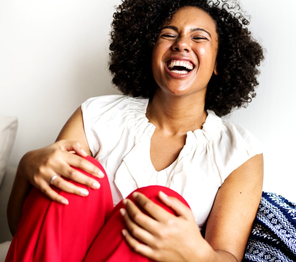 Woman Wearing White Sleeveless Top And Red Bottoms Laughing photo