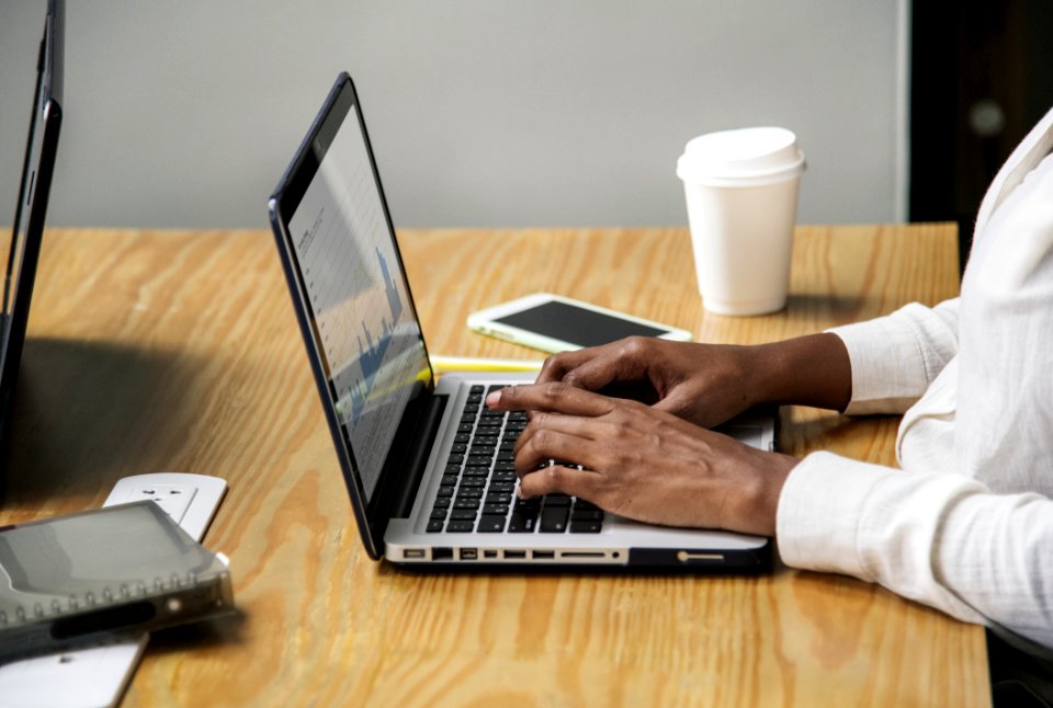 Person Wearing White Long-sleeved Top Using Laptop Computer