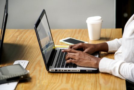 Person Wearing White Long-sleeved Top Using Laptop Computer photo