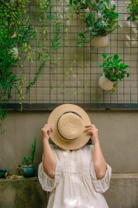 Person Wearing White Elbow-sleeved Top Covering Beige Sun Hat photo