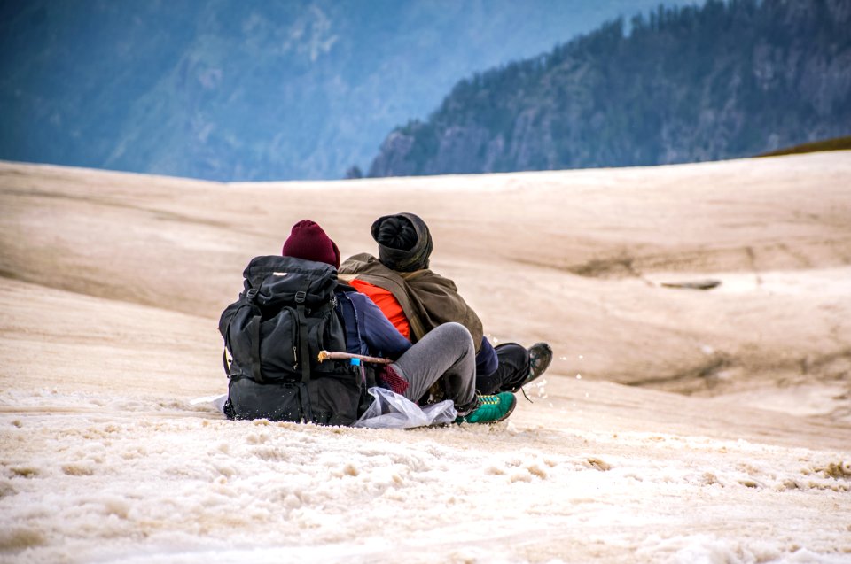 Two People Riding In Sled On Snow