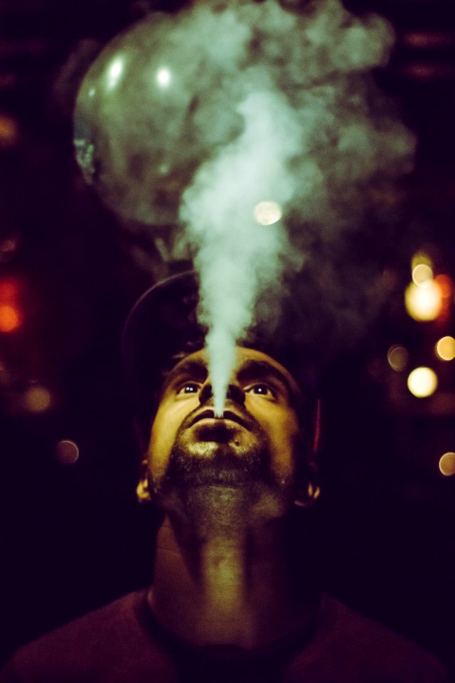 Man Wearing Crew-neck Shirt And Fitted Cap Smoking