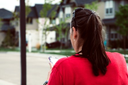 Woman In Red Top Holding Smartphone photo