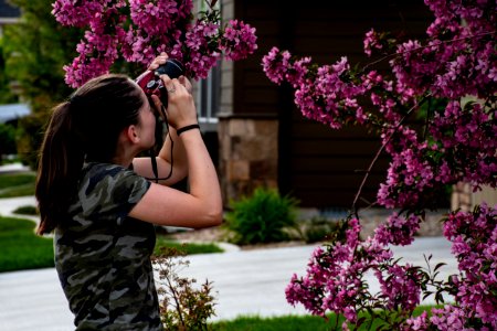 Woman In Gray Camouflage Shirt Holding Camera photo