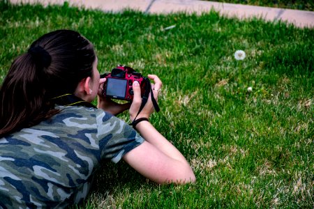 Woman In Camouflage T-shirt Holding Dslr Camera photo
