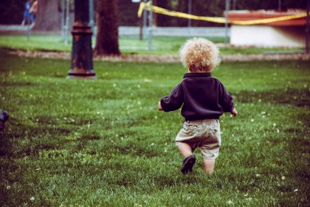 Boy Wearing Brown Shorts Standing On Green Grass photo