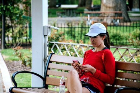 Woman In Red Long-sleeved Top Sitting On Bench photo