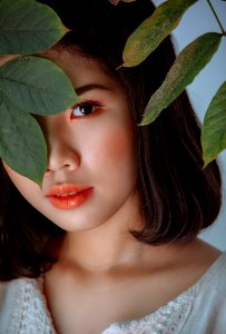 Photography Of Woman Hiding Behind Leaves photo