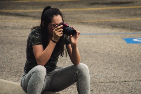 Woman In Gray Pants Sitting While Taking Photo photo