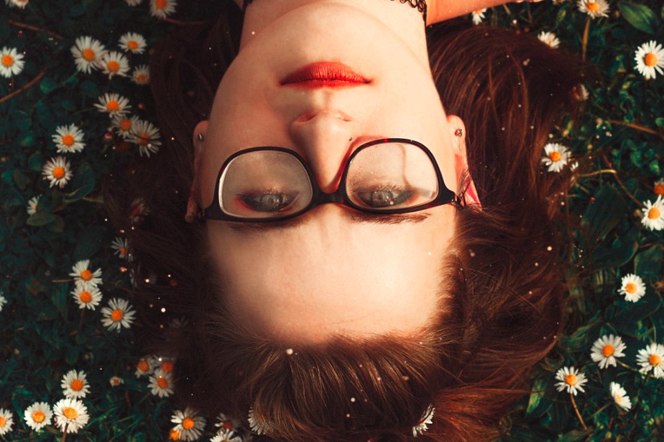 Woman Wearing Eyeglasses Lying On Grass