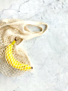 Ripe Banana In White Knitted Bag