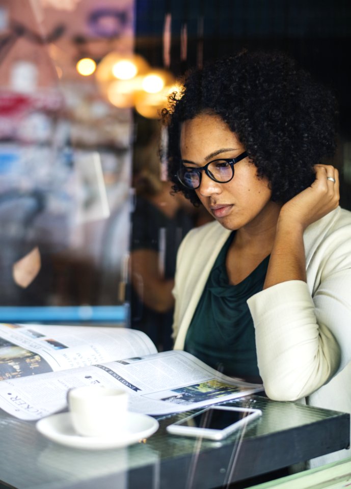 Woman Wearing Eyeglasses And Green Cowl Neck Shirt Looking To A Book