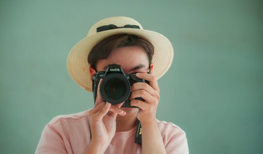 Man In Pink Shirt Holding Dslr Camera photo