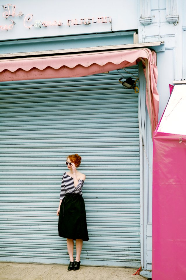 Woman Wearing Black And White Stripe Off-shoulder Dress Standing Near Roll-up Door