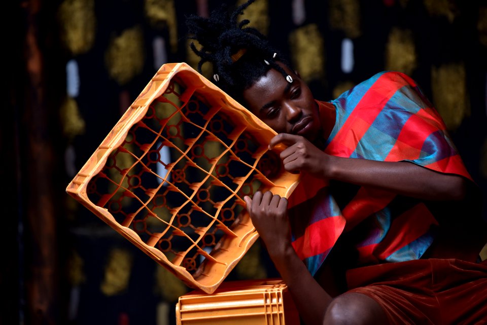 Photography Of A Guy Leaning On Plastic Bottle Crate
