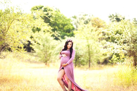 Woman Standing On Grass Field Surrounded With Trees photo
