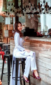 Women Sitting In The Bar Stool In Front Of Bar Counter photo