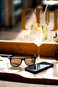 Wine Glass Beside Android Smartphone And Sunglasses