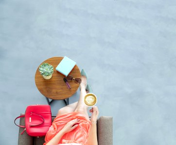 Woman Wearing Peach Skirt Sitting On Sofa Chair Holding A Cup Of Coffee photo