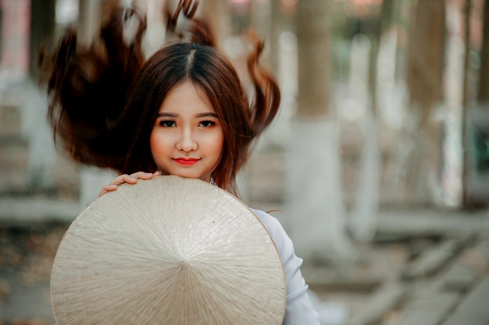 Selective Photography Of Woman Holding Conical Hat photo