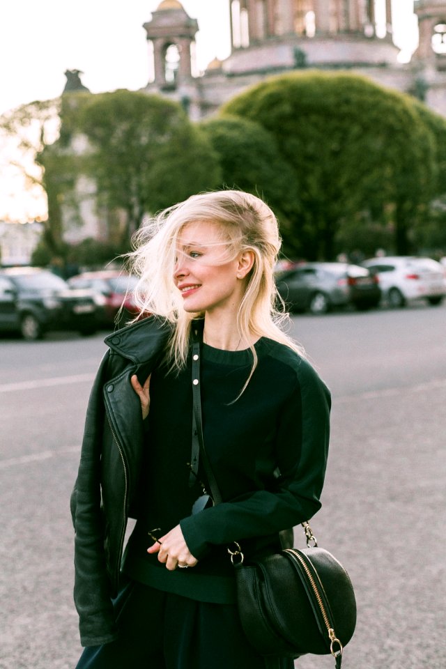 Woman Wearing Leather Jacket And Carrying Bag At The Parking Lot During Day