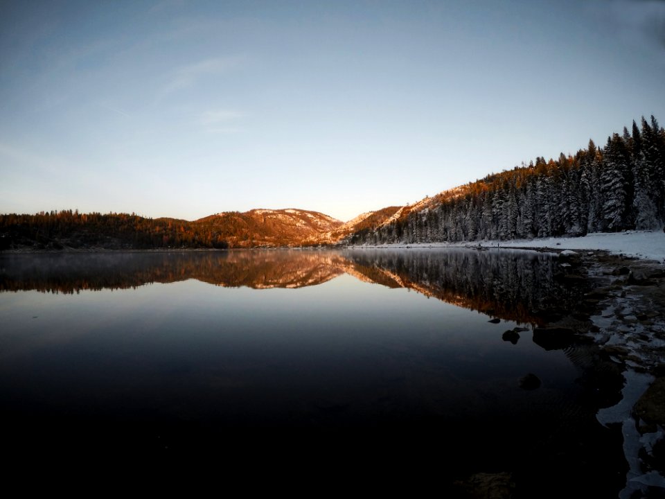 Reflection Of Mountain And Trees On Body Of Water
