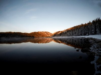 Reflection Of Mountain And Trees On Body Of Water photo