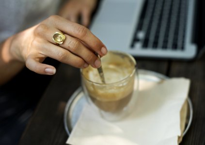 Person Holding Gray Stirrer On Clear Drinking Glass photo