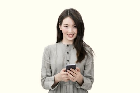 Woman In Gray Button-up Long-sleeved Dress Holding Black Smartphone photo