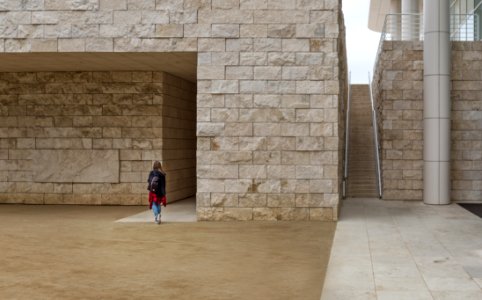 Woman Walking Near Brick Building photo