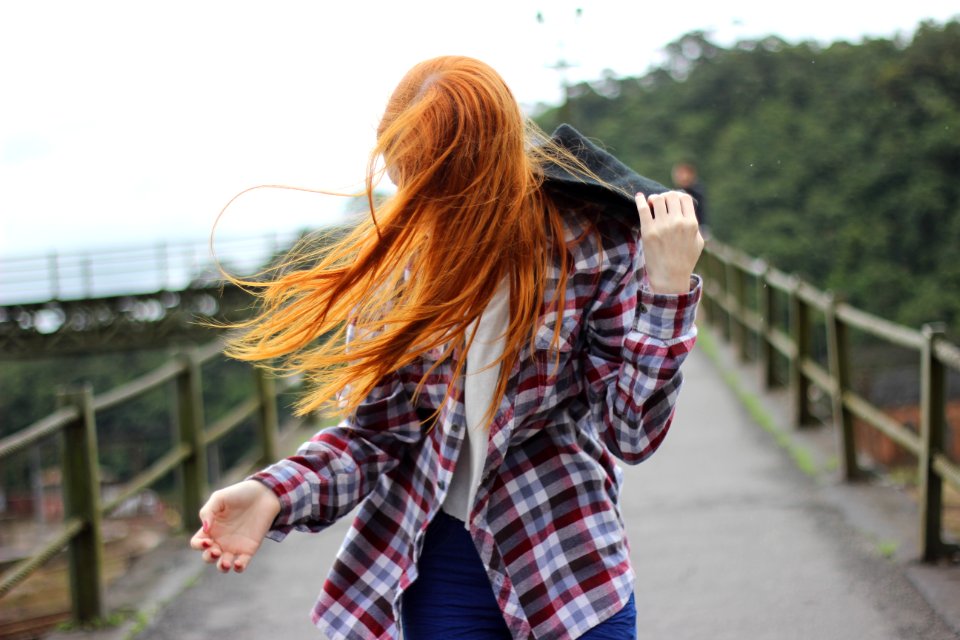 Woman Wearing Plaid Button-up Sport Shirt While Holding Black Hood