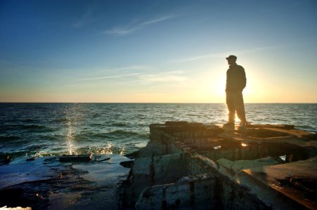 Silhouette Photo Of Man Standing Near The Edge Of Concrete Pavement photo