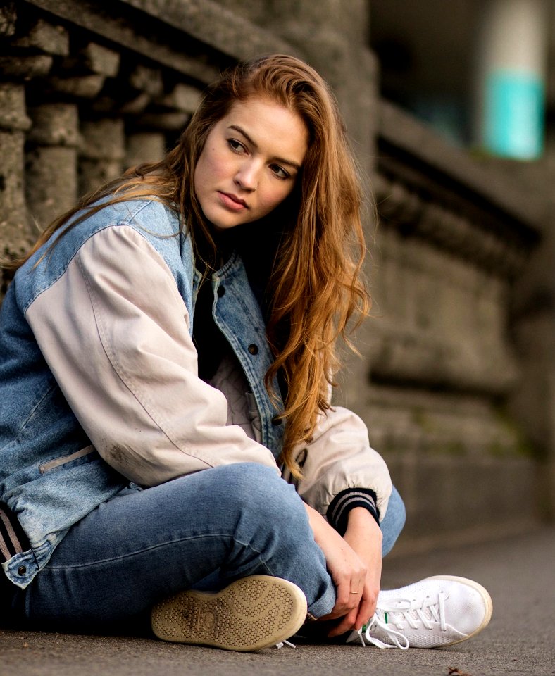 Brown Haired Woman Sitting Beside Gray Concrete Railings