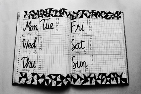 White And Black Weekly Planner On Gray Surface photo