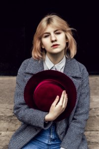 Woman In White Collared Top And Gray Coat Holding Red Fedora photo