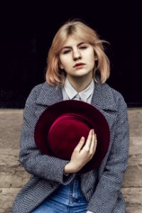 Woman In White Collared Top And Gray Coat Holding Red Fedora