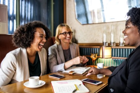 Three Woman Sitting Smiling Inside Room photo