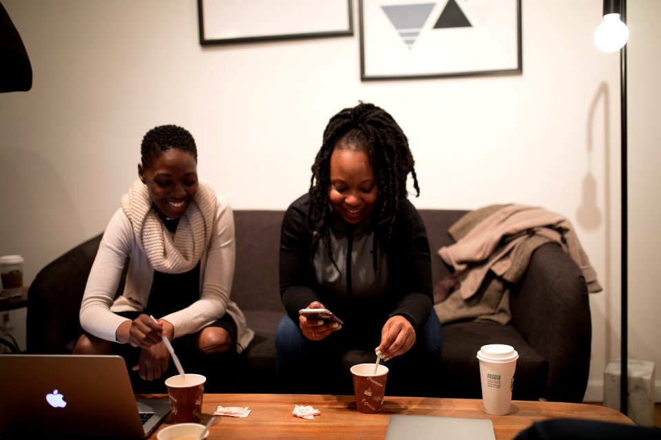 Woman In Black Jacket Sitting Beside Woman In White Sweater