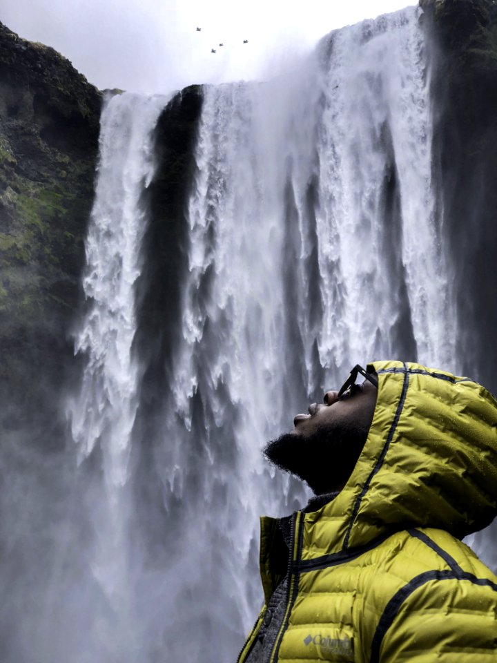 Photography Of Man Wearing Bubble Hoodie Jacket Near Waterfalls