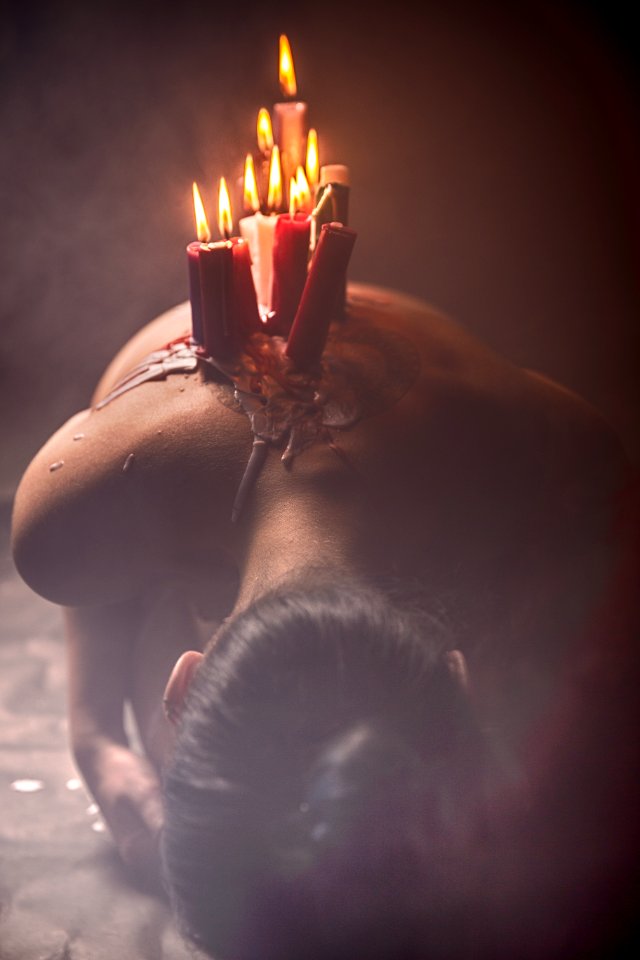 Lit Red And White Candle Lot On Persons Back