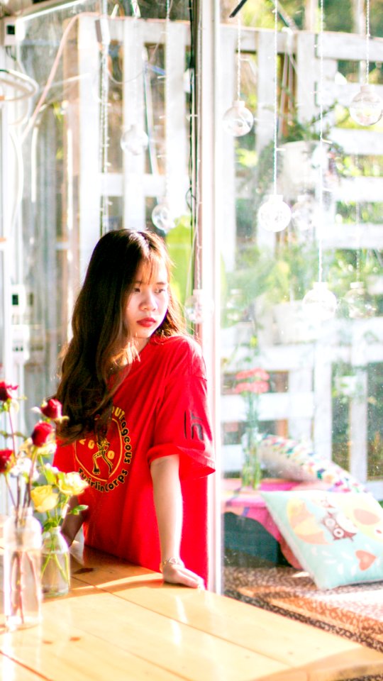 Woman Wearing Red Shirt Standing Near Table