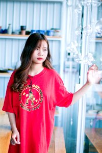Woman Wearing Red Shirt Standing Near Glass Hanging Decor