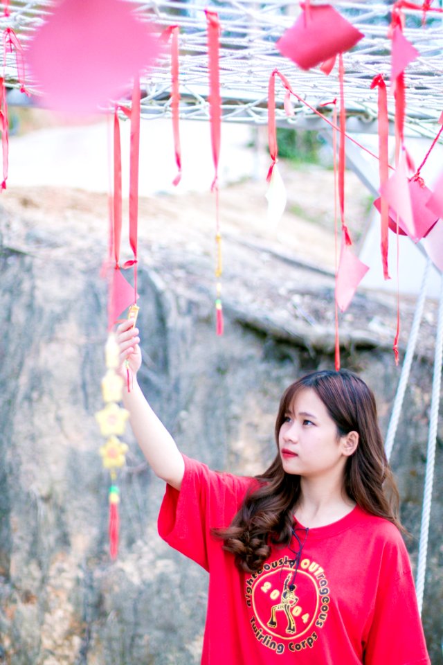 Woman Wearing Red Crew-neck Shirt Near Gray Wall