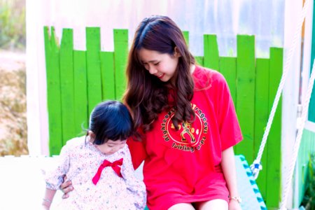 Woman In Red T-shirt Sitting Beside Girl