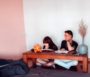 Girl And Boy Sitting In Front Of Brown Wooden Coffee Table photo